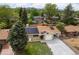 Aerial view of a single-Gathering home with solar panels, lush greenery, and mountain views at 5329 Flower Cir, Arvada, CO 80002