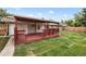 Covered patio featuring wooden beams, built-in benches, and access to the backyard at 5329 Flower Cir, Arvada, CO 80002
