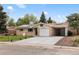 Inviting home exterior featuring a well-manicured lawn, solar panels, attached garage and carport at 5329 Flower Cir, Arvada, CO 80002