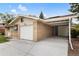 Side view of a brick home showcasing a driveway, garage, and attached carport at 5329 Flower Cir, Arvada, CO 80002
