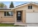 Close up of the front of a brick house, highlighting the black front door and garage at 5329 Flower Cir, Arvada, CO 80002