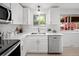 Updated kitchen featuring white cabinets, quartz countertops, and stainless steel appliances at 5329 Flower Cir, Arvada, CO 80002