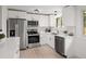 Bright kitchen features stainless steel appliances, white cabinetry, and a stylish marble backsplash at 5329 Flower Cir, Arvada, CO 80002