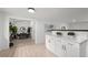 Bright kitchen with white cabinets, quartz countertops, and connection to dining area at 5329 Flower Cir, Arvada, CO 80002