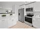 This modern kitchen features bright white cabinets and stainless steel appliances at 5329 Flower Cir, Arvada, CO 80002