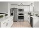 Modern kitchen featuring white cabinets, stainless steel appliances, and light hardwood floors at 5329 Flower Cir, Arvada, CO 80002