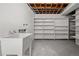 Unfinished laundry room with utility sink and lots of open shelving for storage at 5329 Flower Cir, Arvada, CO 80002