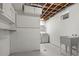Bright basement laundry room with utility sink, washer, dryer, and storage shelves at 5329 Flower Cir, Arvada, CO 80002