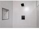 Close up of modern gray tiled shower with built in shelf and matte black shower head at 5329 Flower Cir, Arvada, CO 80002