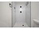 Shower with gray tiled walls, a window, niche and pebbled shower floor at 5329 Flower Cir, Arvada, CO 80002