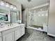 Beautiful bathroom featuring a glass shower, gray cabinets, and hexagon flooring at 9032 Middle Fork St, Littleton, CO 80125