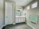 Bright bathroom with gray walls, a white vanity, and hexagon tile floors at 9032 Middle Fork St, Littleton, CO 80125