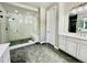 Bathroom with a tiled shower and gray hexagon tile flooring at 9032 Middle Fork St, Littleton, CO 80125
