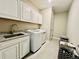 Bright laundry room with granite countertops, ample cabinet space, and a modern washing machine and dryer set at 9032 Middle Fork St, Littleton, CO 80125