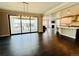 Open-concept living space features hardwood floors, a modern light fixture, and sliding doors to a private balcony at 9032 Middle Fork St, Littleton, CO 80125