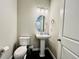 Small powder room with a pedestal sink and black flooring at 9032 Middle Fork St, Littleton, CO 80125