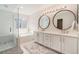 Bright bathroom with a double sink, modern shower with subway tile, and a soaking tub under a window at 9855 Chatswood Trl, Highlands Ranch, CO 80126