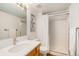 Bright bathroom with modern vanity, quartz countertop, and shower with sliding glass door at 9855 Chatswood Trl, Highlands Ranch, CO 80126