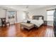 Bright bedroom featuring hardwood floors, a plush bed, and large windows with views of the neighborhood at 9855 Chatswood Trl, Highlands Ranch, CO 80126
