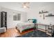 Cozy bedroom features hardwood floors, a ceiling fan, and a desk for studying and working at 9855 Chatswood Trl, Highlands Ranch, CO 80126