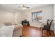 Bright living room with hardwood floors, a ceiling fan, and large windows overlooking the neighborhood at 9855 Chatswood Trl, Highlands Ranch, CO 80126