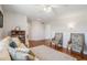 Spacious living area features hardwood floors, two chairs and a cozy sofa illuminated by a ceiling fan at 9855 Chatswood Trl, Highlands Ranch, CO 80126