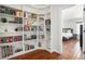 Beautiful office area with large bookshelf and adjacent doorway to the bedroom with hardwood floors at 9855 Chatswood Trl, Highlands Ranch, CO 80126