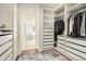 Spacious walk-in closet with custom shelving and drawers, plus a view of the light-filled ensuite bathroom at 9855 Chatswood Trl, Highlands Ranch, CO 80126