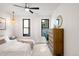 Comfortable bedroom with wood dresser, ceiling fan, and large windows at 1838 Pearl # C, Boulder, CO 80302