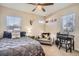 Comfortable bedroom featuring a cozy seating area, a ceiling fan, and ample natural light from the windows at 3361 Mariposa St, Denver, CO 80211