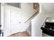 Bright entryway featuring a white front door, light wood floors, and staircase with plush gray carpet at 4443 N Quatar Ct, Aurora, CO 80019