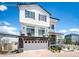 A charming two-story home boasting a white exterior, stone accents, and a paved driveway under a bright blue sky at 4443 N Quatar Ct, Aurora, CO 80019