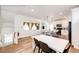 A bright, open-concept kitchen and dining area with hardwood floors and modern finishes at 4443 N Quatar Ct, Aurora, CO 80019