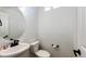 Clean powder room with a pedestal sink, round mirror, and white toilet against a neutral wall at 4443 N Quatar Ct, Aurora, CO 80019