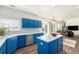 Modern kitchen featuring sleek blue cabinets, white countertops, stainless steel appliances, and hardwood flooring at 9756 E 113Th Ave, Commerce City, CO 80640