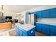 Stylish kitchen with a center island, stainless steel refrigerator, and bright blue cabinets with lots of storage at 9756 E 113Th Ave, Commerce City, CO 80640