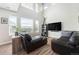 Bright living room featuring a high ceiling, lots of natural light, hardwood flooring, and a comfortable leather sofa at 9756 E 113Th Ave, Commerce City, CO 80640