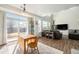 Open-concept living and dining area with high ceilings, hardwood floors, and sliding glass doors that bring in natural light at 9756 E 113Th Ave, Commerce City, CO 80640