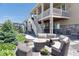 Backyard patio area with stone tile, outdoor seating, and a landscaped yard at 8761 S Wenatchee Ct, Aurora, CO 80016