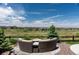 Lush and green backyard featuring a fire pit with cushioned seating and mature trees at 8761 S Wenatchee Ct, Aurora, CO 80016