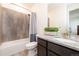 Bathroom featuring wood-look tile, granite countertop, tub and shower with tiled wall at 8761 S Wenatchee Ct, Aurora, CO 80016