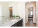 Bathroom featuring a granite countertop vanity and views of an ensuite with tile flooring at 8761 S Wenatchee Ct, Aurora, CO 80016