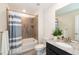 Bright bathroom featuring tub/shower combo with blue shower curtain and granite counter at 8761 S Wenatchee Ct, Aurora, CO 80016