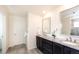 Bathroom features a double sink vanity with granite countertops, decorative accents, and tile flooring at 8761 S Wenatchee Ct, Aurora, CO 80016