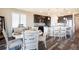 Light-filled dining area features a farmhouse style table, decorative lighting, and open kitchen at 8761 S Wenatchee Ct, Aurora, CO 80016