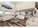 Open living space with soaring ceilings, large windows, comfortable seating, and hardwood floors at 8761 S Wenatchee Ct, Aurora, CO 80016