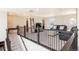 Carpeted loft area featuring railings, a TV, and leather sofas for seating at 8761 S Wenatchee Ct, Aurora, CO 80016