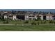 A serene neighborhood street view showcasing well-maintained homes and green spaces against a backdrop of snow-capped mountains at 8761 S Wenatchee Ct, Aurora, CO 80016