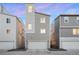 Modern gray three-story home with attached garage, complemented by sleek lines and a contemporary design at 12261 Farmview St, Thornton, CO 80241
