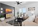Bright living room features large windows, plush seating, modern decor, and a dark accent wall with a flat screen television at 12261 Farmview St, Thornton, CO 80241